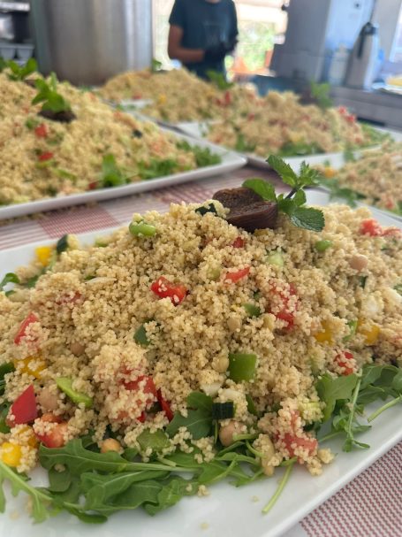 Bunte Couscous-Salatplatte mit frischem Gemüse und Kräutern.