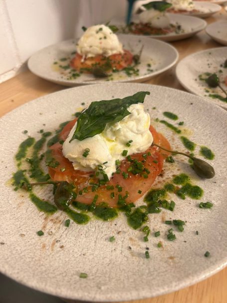 Geräucherter Lachs mit Sahne und Kräutern auf einem Teller, dekoriert mit frischen Blättern.